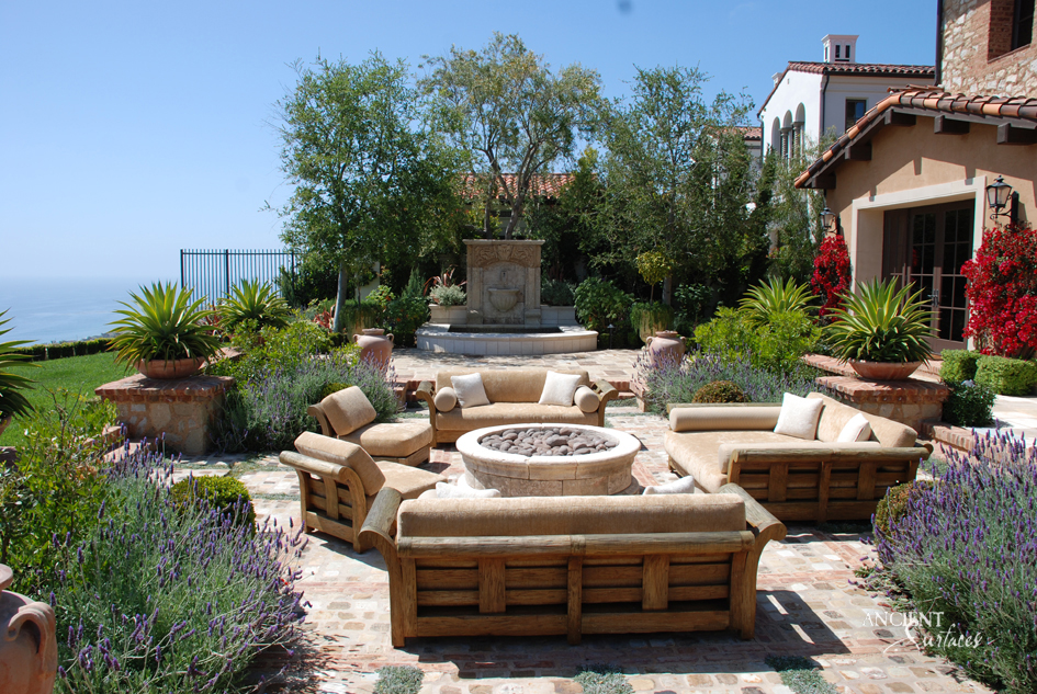 Rustic limestone fire pit by Ancient Surfaces, capturing the essence of outdoor living and the company's commitment to preserving the beauty of ancient surfaces.