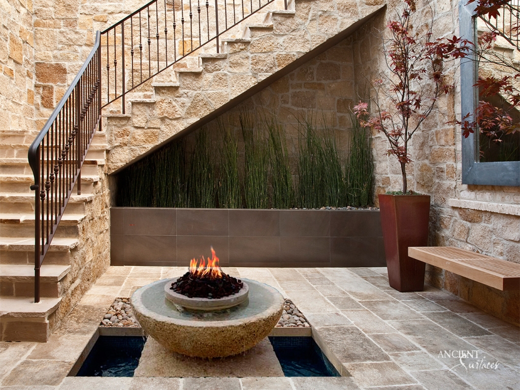 Ancient Surfaces' limestone fire pit taking center stage in a beautiful villa, creating a cozy and inviting atmosphere.