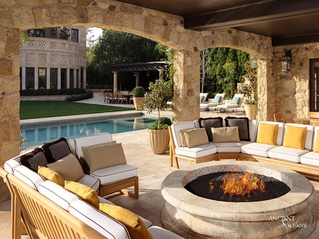 Stunning limestone fire pit by Ancient Surfaces, showcasing intricate carvings and a weathered texture.